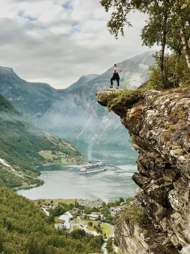 Will You Regret Not Traveling? How to Stop Making Excuses and Finally Go! Hiker looking off cliff into distance, depicting freedom, strength and a journey in action.